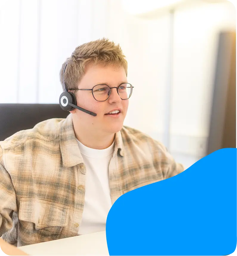 Support-Mitarbeiter mit Headset am Arbeitsplatz.
