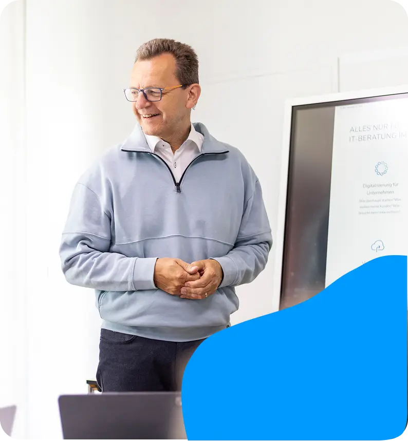 Mann mit Präsentationsunterlagen am Whiteboard.